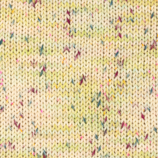 Detailaufnahme eines Strickstücks aus der Wolle DROPS Fiesta in der Farbe 47 saure bonbons. Die Farbe saure bonbons hat einen cremefarbenen Grundton und viele bunte Flecken drauf.