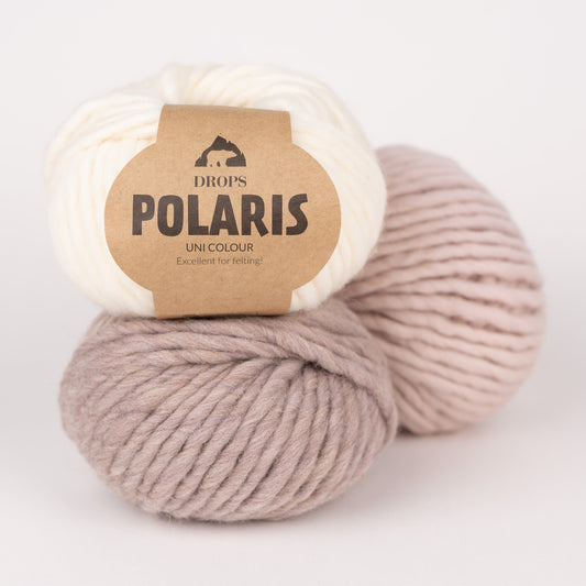 Drei Knäuel der Wolle DROPS Polaris in den Farben 01 natur (oben), 06 hellbeige (unten) und 13 marshmallow (rechts).