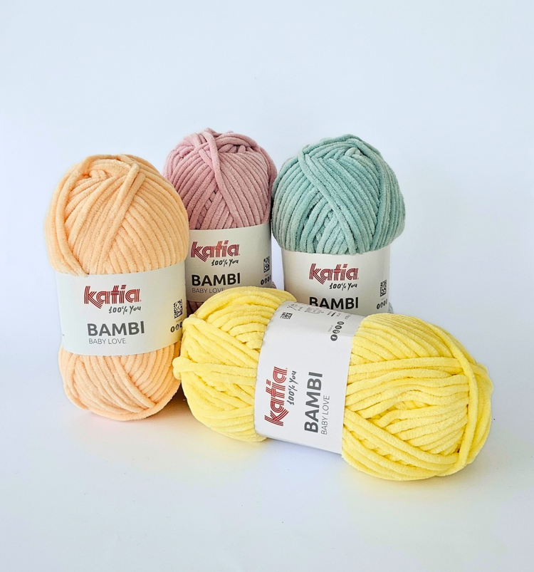 Vier Knäuel Katia Bambi Chenillegarn in den Farben 342 apricot, 326 altrosa, 328 aqua und 329 gelb (von links nach rechts).
