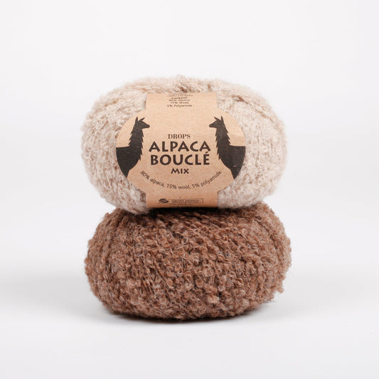 Zwei Knäuel der Wolle DROPS Alpaca Bouclé in den Farben 2020 hellbeige (oben) und 0602 braun (unten).