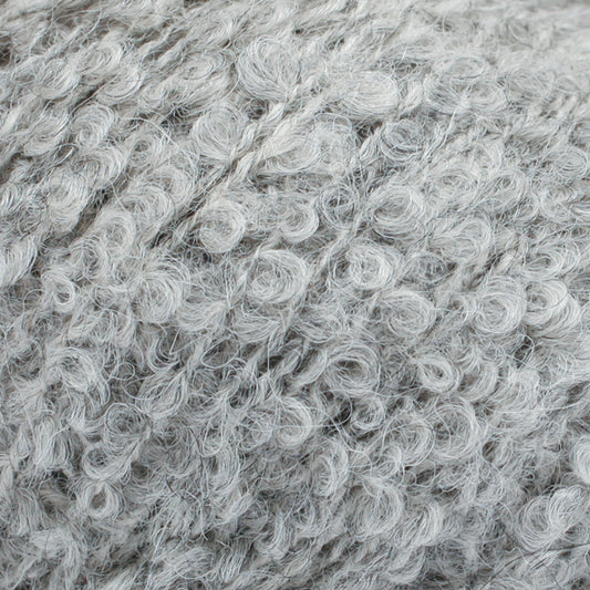 Detailaufnahme von der Wolle DROPS Alpaca Bouclé in der Farbe 5110 hellgrau.