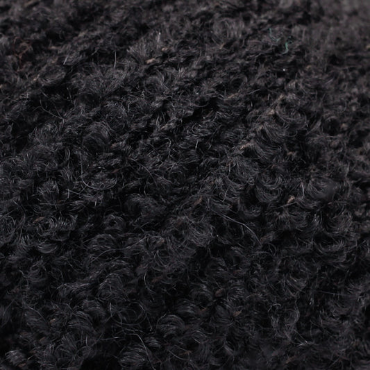 Detailaufnahme von der Wolle DROPS Alpaca Bouclé in der Farbe 8903 schwarz. 