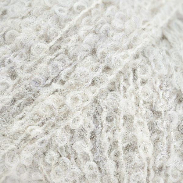 Detailaufnahme von der Wolle DROPS Alpaca Bouclé in der Farbe 8907 kristallgrau. Kristallgrau ist ein sehr helles Grau mit einigen dunkleren Fasern.