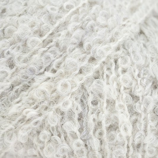 Detailaufnahme von der Wolle DROPS Alpaca Bouclé in der Farbe 8907 kristallgrau. Kristallgrau ist ein sehr helles Grau mit einigen dunkleren Fasern.