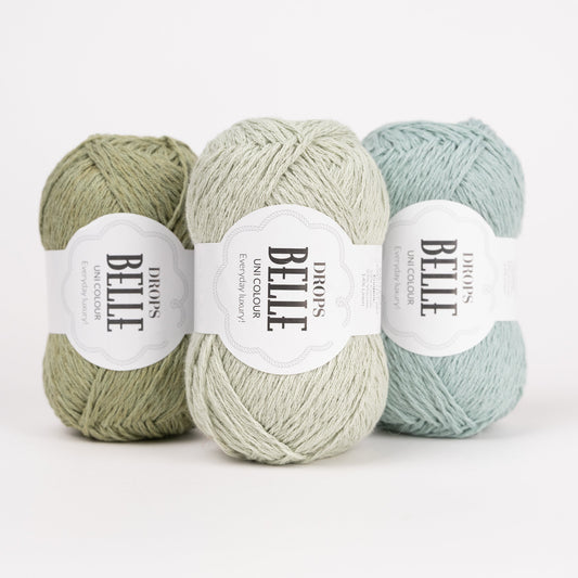 Drei Knäuel der Wolle DROPS Belle in den Farben 10 moosgrün, 32 pfefferminze und 31 seegrün (von links nach rechts).