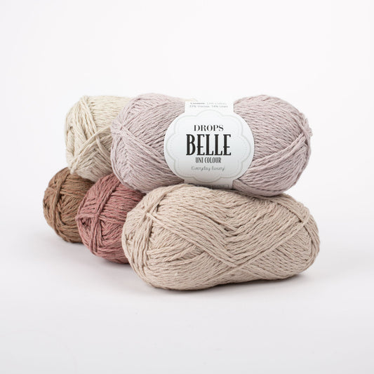 Fünf Knäuel der Wolle DROPS Belle in den Farben 25 waldbraun (links unten), 21 rosenmandel (Mitte unten), 24 sand (rechts unten), 22 rosenwasser (rechts oben) und 23 minzcreme (links oben).