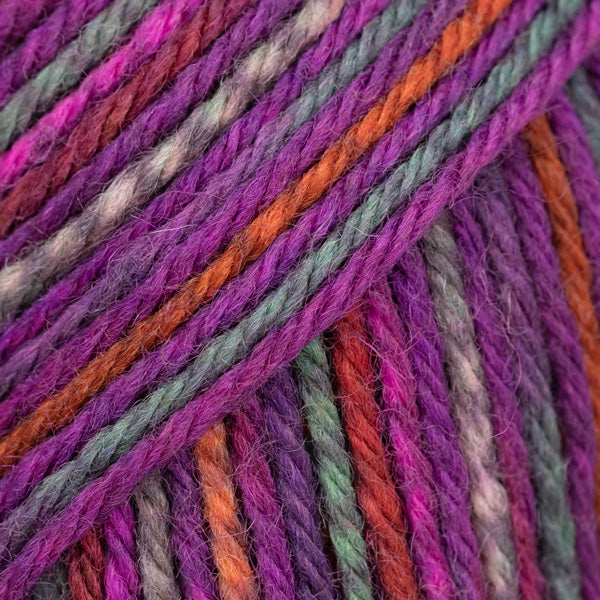 Detailaufnahme von der Wolle DROPS Fiesta in der Farbe 46 waldbeeren. Die Farbe waldbeeren ist eine Mischung aus verschiedenen Pink-, Lila-, Rost- und Grautönen.