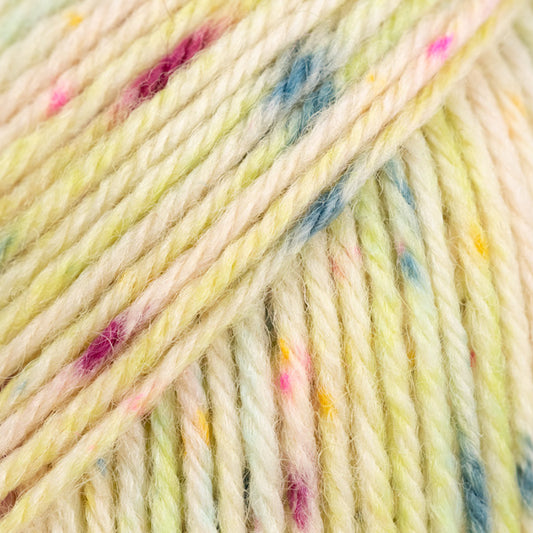 Detailaufnahme von der Wolle DROPS Fiesta in der Farbe 47 saure bonbons. Die Farbe saure bonbons hat einen cremefarbenen Grundton und viele bunte Flecken drauf. 