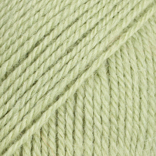 Detailaufnahme von der Wolle DROPS Flora in der Farbe 16 pistazie. Pistazie ist ein zarter Grünton.