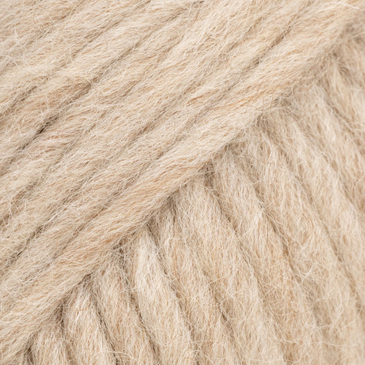 Detailaufnahme von der Wolle DROPS Snow in der Farbe 128 hafermilch. Die Farbe hafermilch ist ein cremig-beiger Farbton.