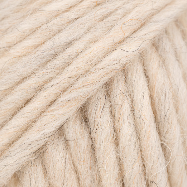 Detailaufnahme von der Wolle DROPS Snow in der Farbe 134 marmor. Die Farbe marmor ist ein hellbeiger Farbton mit etwas dunkleren eingezwirnten Fäden.