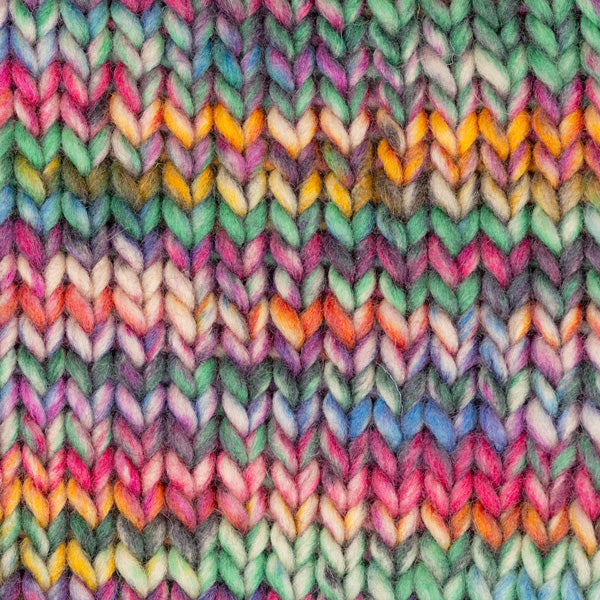 Detailaufnahme eines Strickstücks mit der Wolle DROPS Snow in der Farbe 136 gartenparty print. Die Farbe besteht aus cremefarbenen, orangen, blauen, grünen und dunkelgrauen Abschnitten.