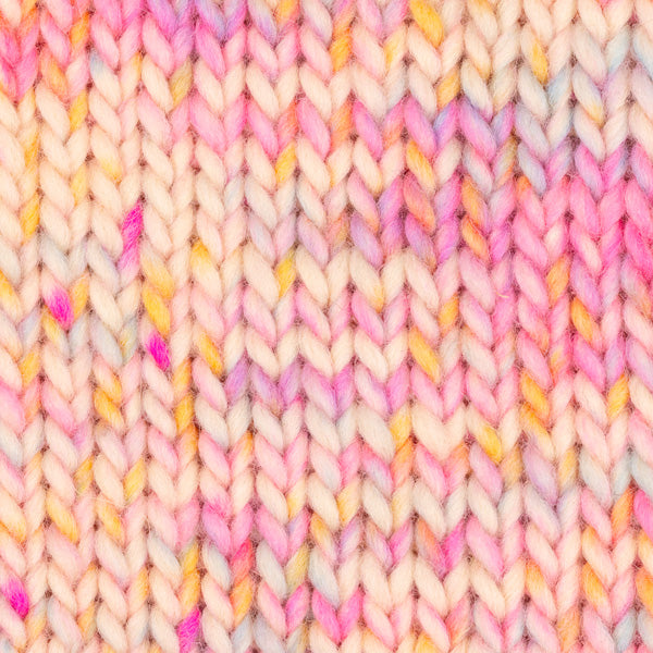 Detailaufnahme eines Strickstücks mit der Wolle DROPS Snow in der Farbe 139 zuckerstreusel print. Die Farbe besteht aus cremefarbenen, orangen, pinken und gelben Abschnitten.