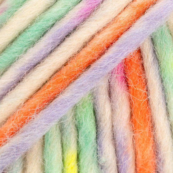 Detailaufnahme von der Wolle DROPS Snow in der Farbe 140 bunter karneval print. Die Farbe besteht aus cremefarbenen, orangen, grünen, gelben und lila Abschnitten.