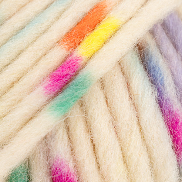Detailaufnahme von der Wolle DROPS Snow in der Farbe 141 knallige streusel print. Die Farbe besteht aus cremefarbenen, orangen, blauen, grünen, pinken und gelben Abschnitten.