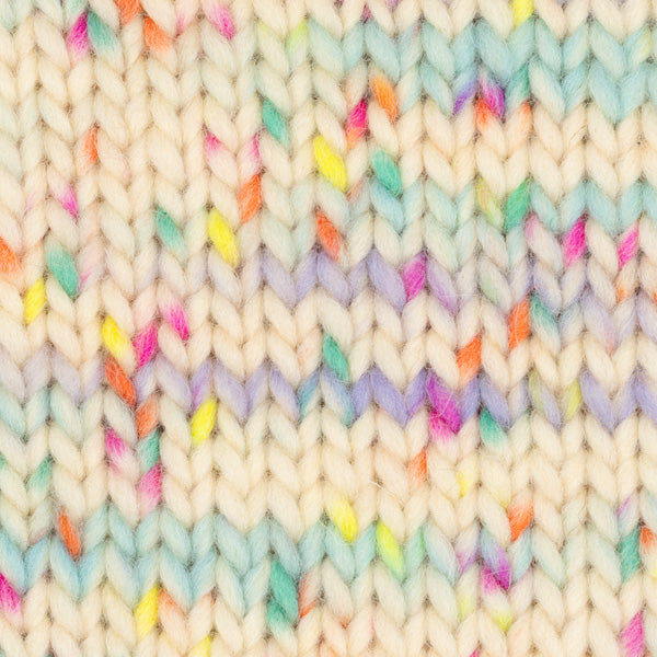Detailaufnahme eines Strickstücks mit der Wolle DROPS Snow in der Farbe 141 knallige streusel print. Die Farbe besteht aus cremefarbenen, orangen, blauen, grünen, pinken und gelben Abschnitten.