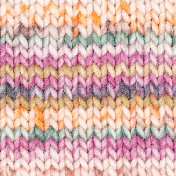 Detailaufnahme eines Strickstücks mit der Wolle DROPS Snow in der Farbe 142 herbstkräuter print. Die Farbe besteht aus cremefarbenen, orangen, braunen und dunkelrosafarbenen Abschnitten.