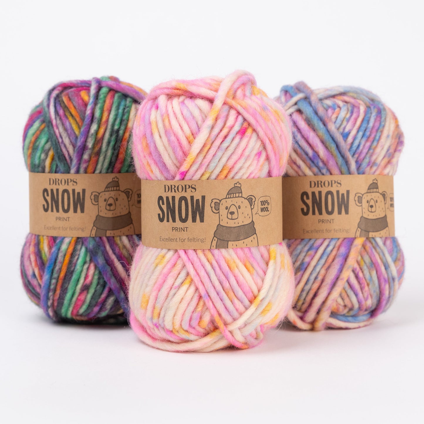 Drei Knäuel der Wolle DROPS Snow in den Print-Farben 143 feenmärchen, 139 zuckerstreusel und 136 gartenparty (von rechts nach links).
