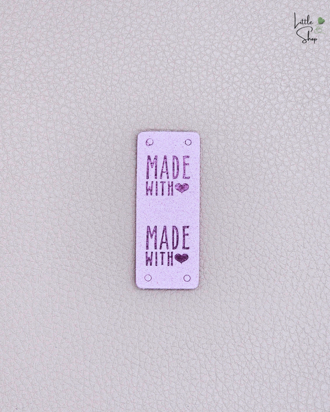 Lilafarbenes Klapplabel in Velouroptik mit dem Schriftzug "Made with ❤️"
